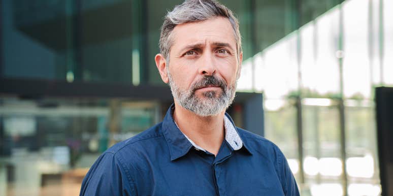 serious man standing in front of office building