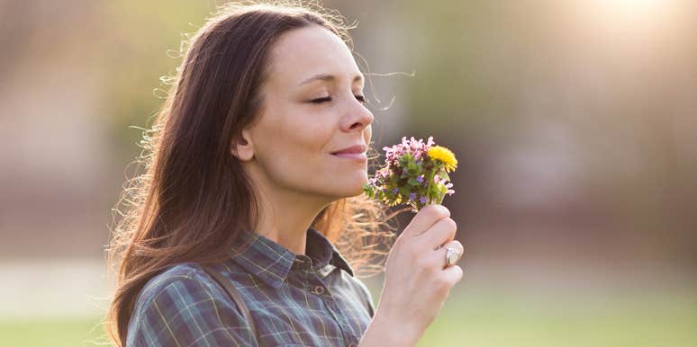 woman smelling flowers outside