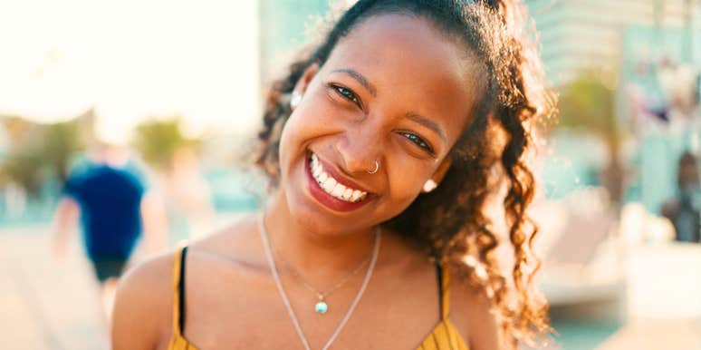 Confident young woman smiling warmly during a relaxed, engaging conversation