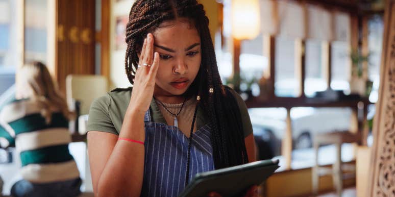 frustrated woman using tablet at restaurant