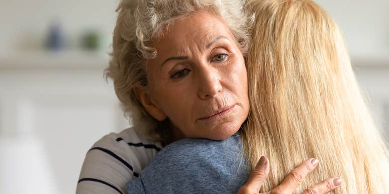 mother hugging adult daughter unaware that she's struggling