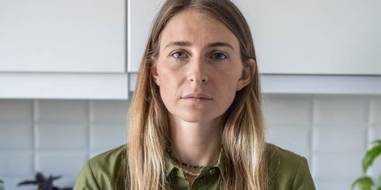Woman in her 40s in kitchen looking physically and spiritually exhausted