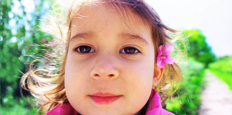 A woman holding a microphone and tablet while speaking indoors in a relaxed setting.