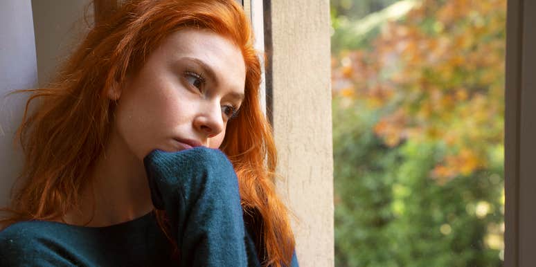 heartbroken woman looking out window
