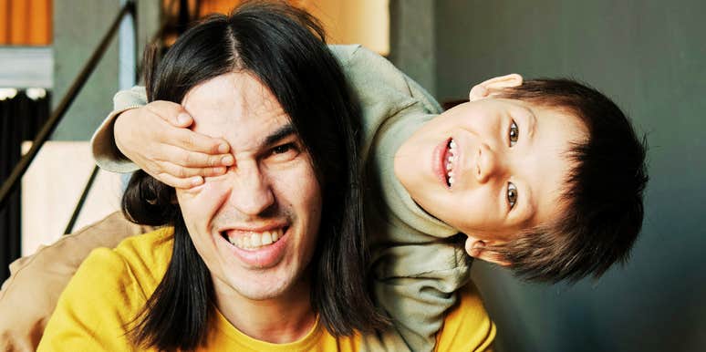 Adult and young child smiling together inside a home.