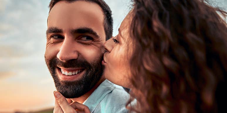 woman kissing man's cheek who is being fake nice