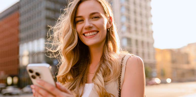 woman on the street using her phone while walking