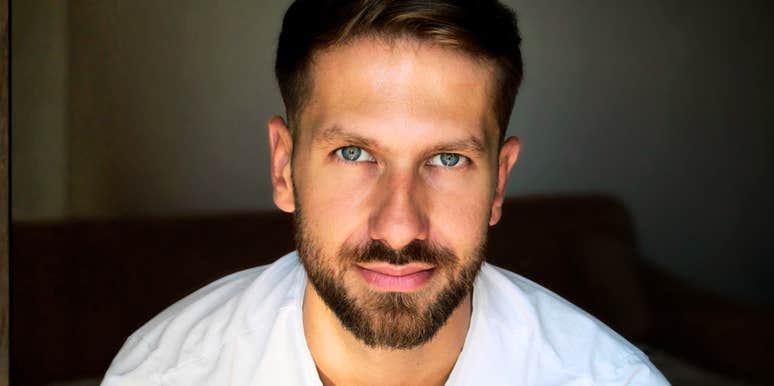 Man looking directly at the camera with a neutral expression indoors.