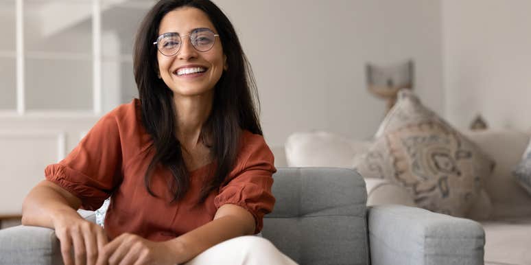 smiling woman sitting on couch at home