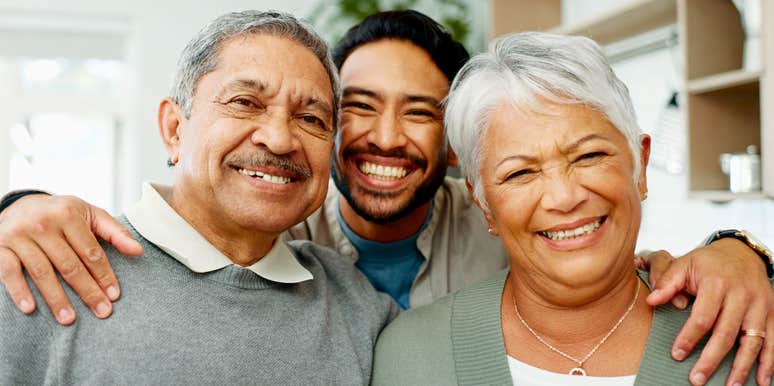 man hugging his parents with whom he has a loving relationship