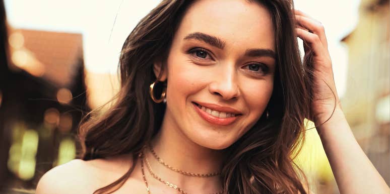 close-up portrait of thoughtful woman in warm natural light with soft confident smile, subtle expression suggesting emotional awareness and brain-based insights that influence relationships