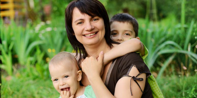 Mother smiling outdoors with her children, reflecting personal growth and positive changes after divorce
