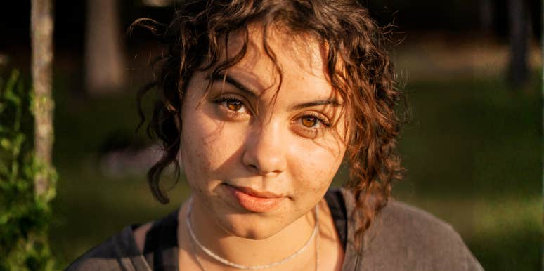 close-up of thoughtful young woman with soft, reflective expression in warm golden light