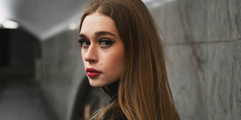 Woman looking over her shoulder with a serious expression, reflecting inner doubts and caution about her relationship before marriage