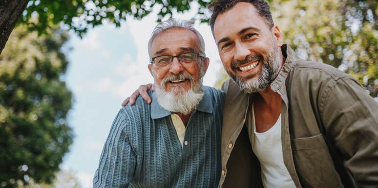 adult man smiling with dad while standing outside