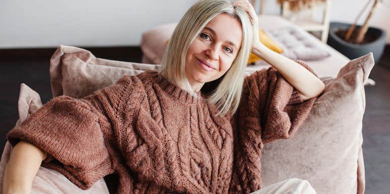 smiling woman relaxing on couch at home