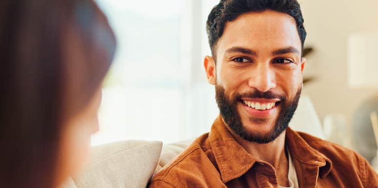 man smiling while talking to partner he loves more than she realizes