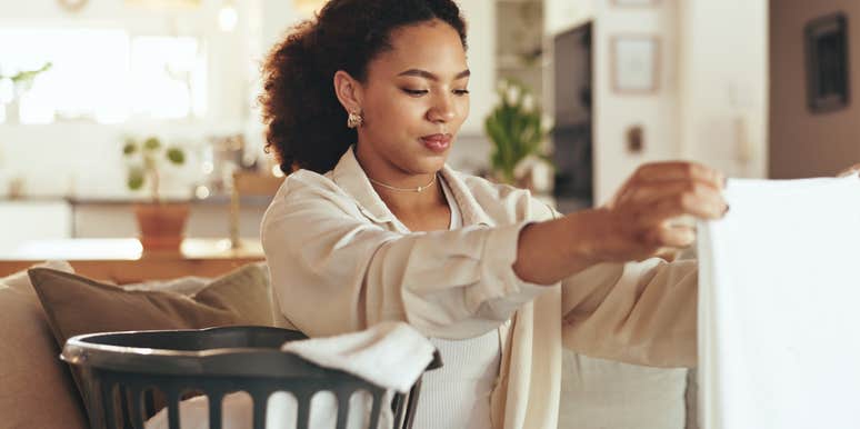 woman folding clothes from laundry baske