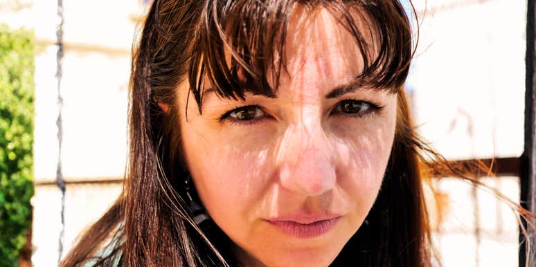 serious woman with intense direct gaze in bright natural sunlight