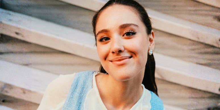 A woman smiling gently while looking at the camera.