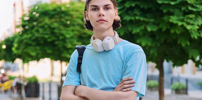 college student standing outside with arms crossed