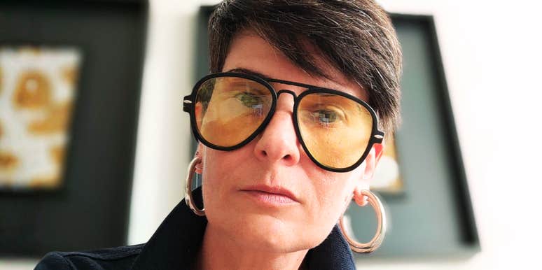 Middle age woman in glasses, leaning forward. 