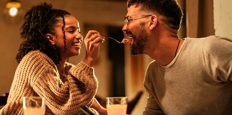 Playful couple enjoying dinner together, highlighting romantic habits noticed by wives, according to a clinical psychologist”