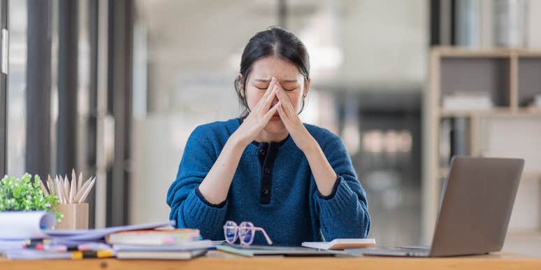 woman crying at work because she needs heartbreak leave after a breakup