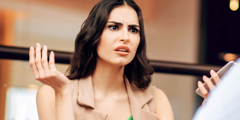 A woman gesturing while talking indoors.