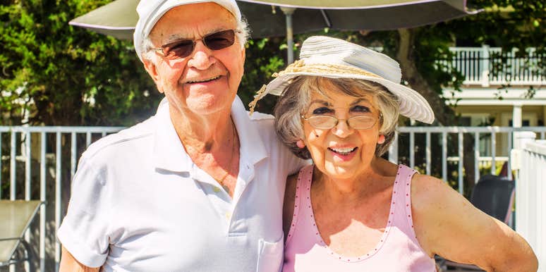 A happy senior couple laughing on a beach vacation, representing the hard-earned, authentic wisdom about love shared by Baby Boomers who have been together for decades.