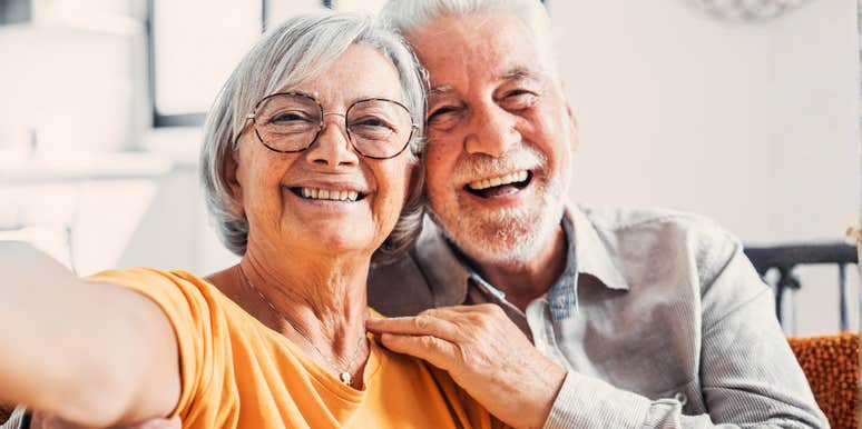 A happy older couple hugging and smiling, illustrating that choosing separate beds or 'sleep divorce' can actually strengthen a relationship and improve comfort in later years.