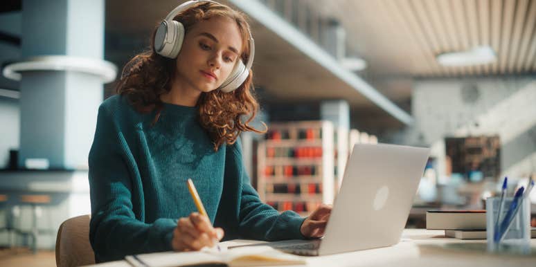 college student working in library with laptop