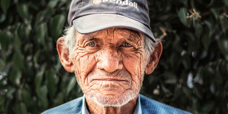 96-year-old man outdoors looking directly at the camera, illustrating a lifetime of devotion and how small acts of care can redefine ideas of romance
