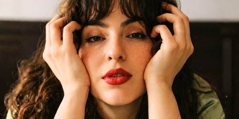 Woman with hands on her cheeks looking exhausted, illustrating the mental fatigue of worrying about others’ opinions and strategies to let go