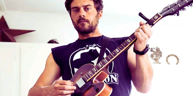 Gen-X author playing his guitar in a home kitchen, illustrating the 'success' found in personal hobbies and creative fulfillment over corporate career climb.