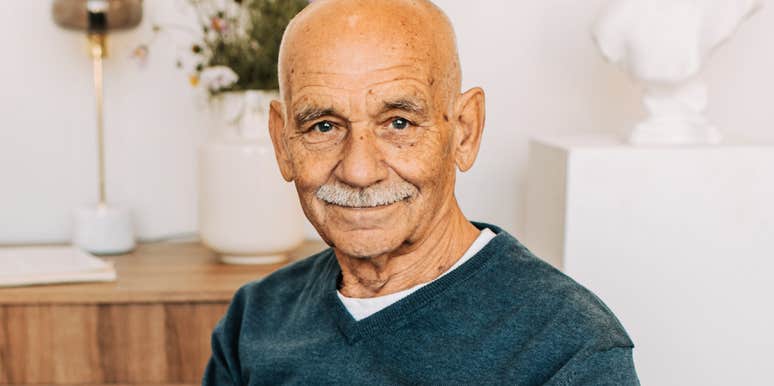 An elderly man in a blue sweater, representing the wisdom and commitment of husbands in long-term, happy marriages.