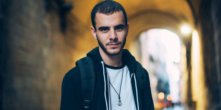 Man with personality traits that make him unattractive standing in an arch