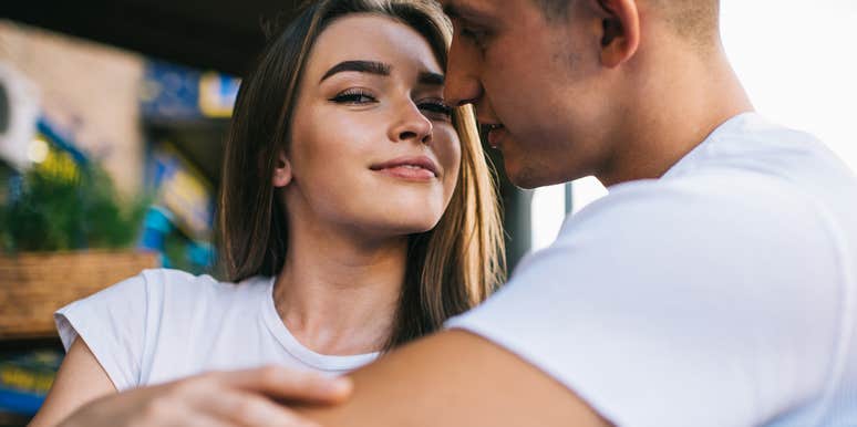 Man hugging a woman he probably shouldn't marry as she looks slyly at camera