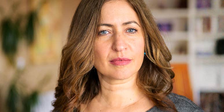 A woman with an intense, reflective expression, capturing the mindset of a self-assured individual who understands the value of setting boundaries and acting on her own behalf.