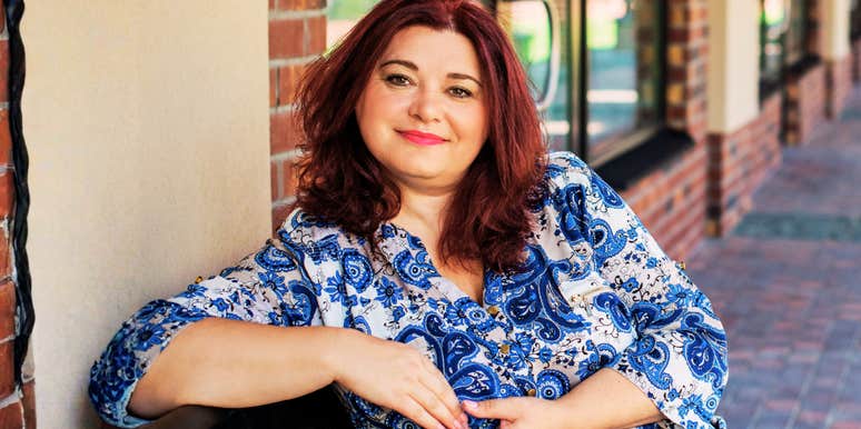 A confident, smiling woman in her fifties enjoying a sunny day in the city, embodying the 'faith in herself' and modern vitality described in her story of mid-life romance