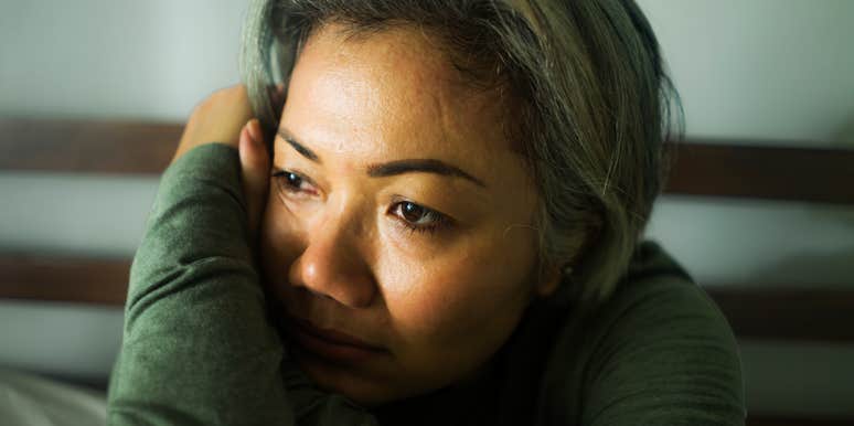 A mature woman with grey hair looking distant and detached, illustrating the 'subtle signs' of dissociation and the difference between stress and a freeze response.
