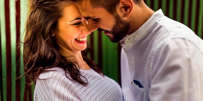 A man leaning into a woman in a cute, spontaneous moment, illustrating the 'micro-bids' for connection that sustain long-term marriages.