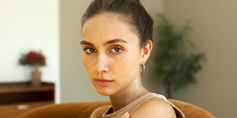 A pensive and tired woman reflecting on a difficult conversation, representing the 'Grey Rock' method and other protective strategies against narcissistic manipulation.