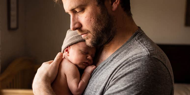 Dad protects newborn.