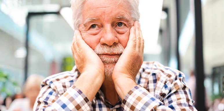 Sad man - handsome bearded elderly man sitting thoughtfully holding his face in the hand, concept of unhappiness, stress depression people