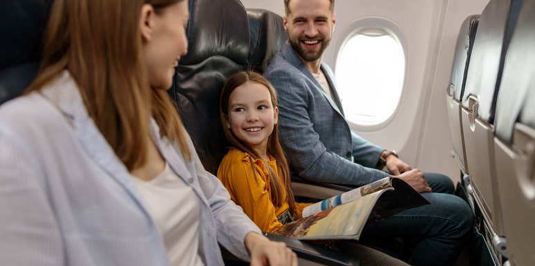parents with young daughter smiling while sitting on plane