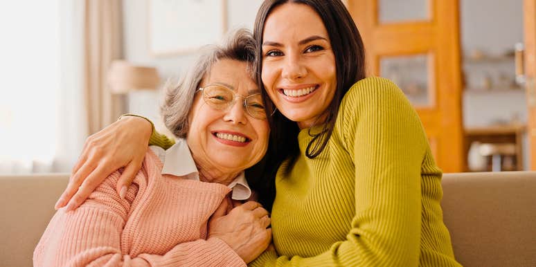 millennial woman hugging her boomer mother smiling