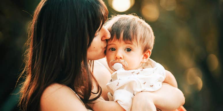 Mother embracing child closely. 