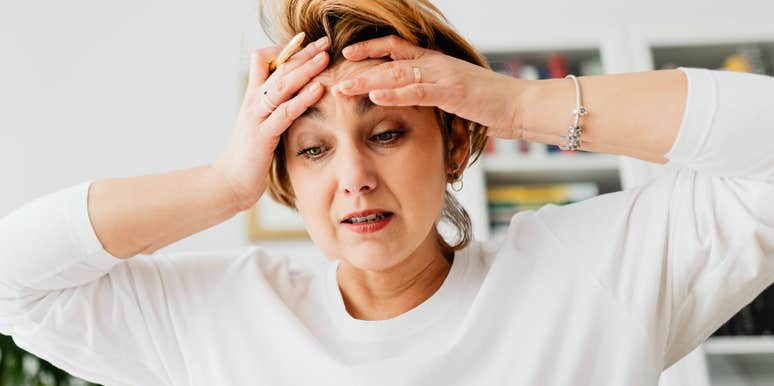 An overwhelmed woman looking stressed; a visual of the high-tension moments where a quick breathing exercise can instantly calm the nervous system.