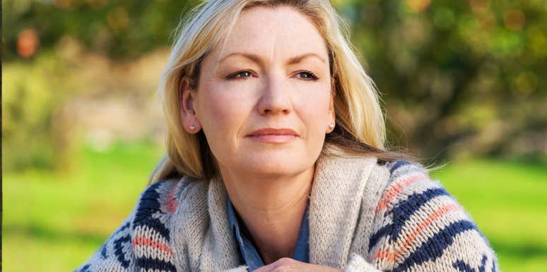 An attractive, thoughtful middle-aged woman looking concerned, capturing the emotional and financial weight of being an only child responsible for parents with no retirement savings.